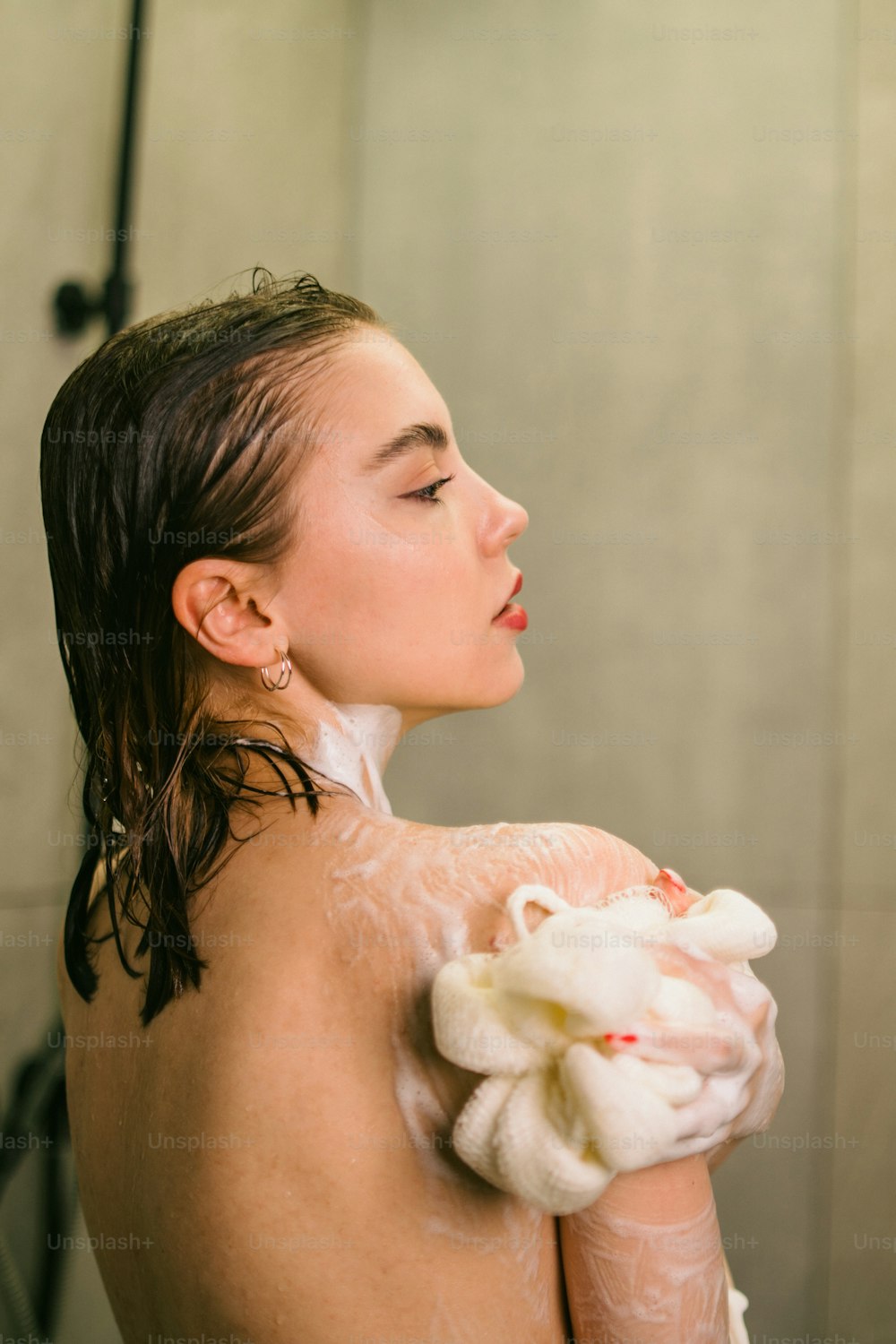 a woman in a bath room with a towel on her shoulder