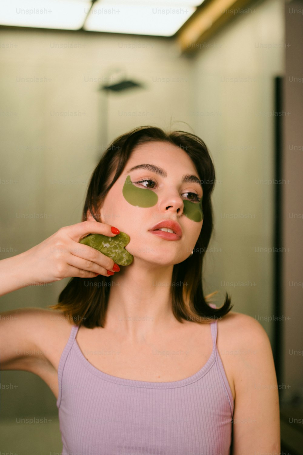 a woman holding a piece of cucumber in front of her face