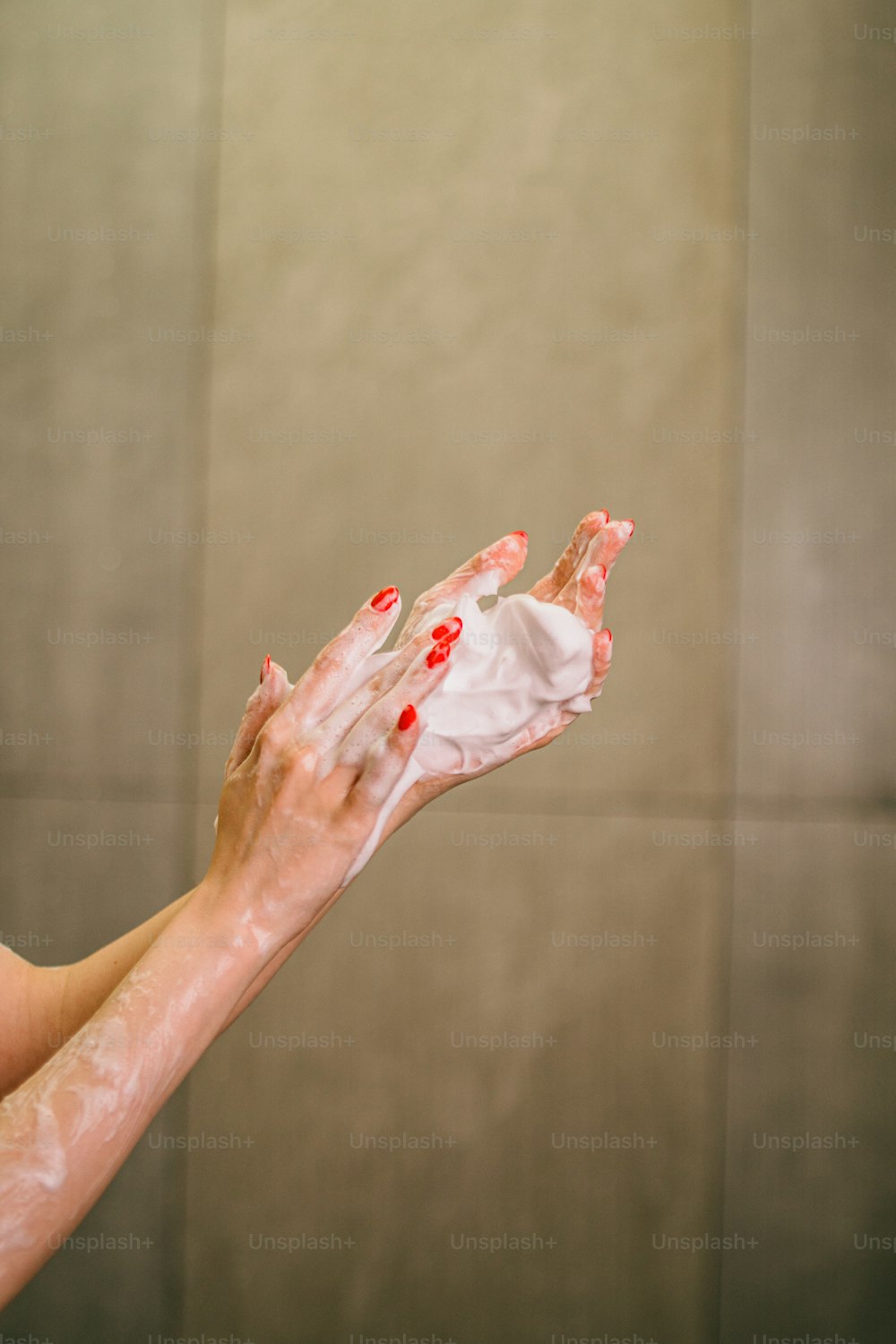 Una mujer extendiendo sus manos con pintura blanca y roja sobre ellas