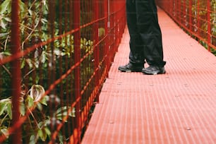 a person walking across a red bridge over water