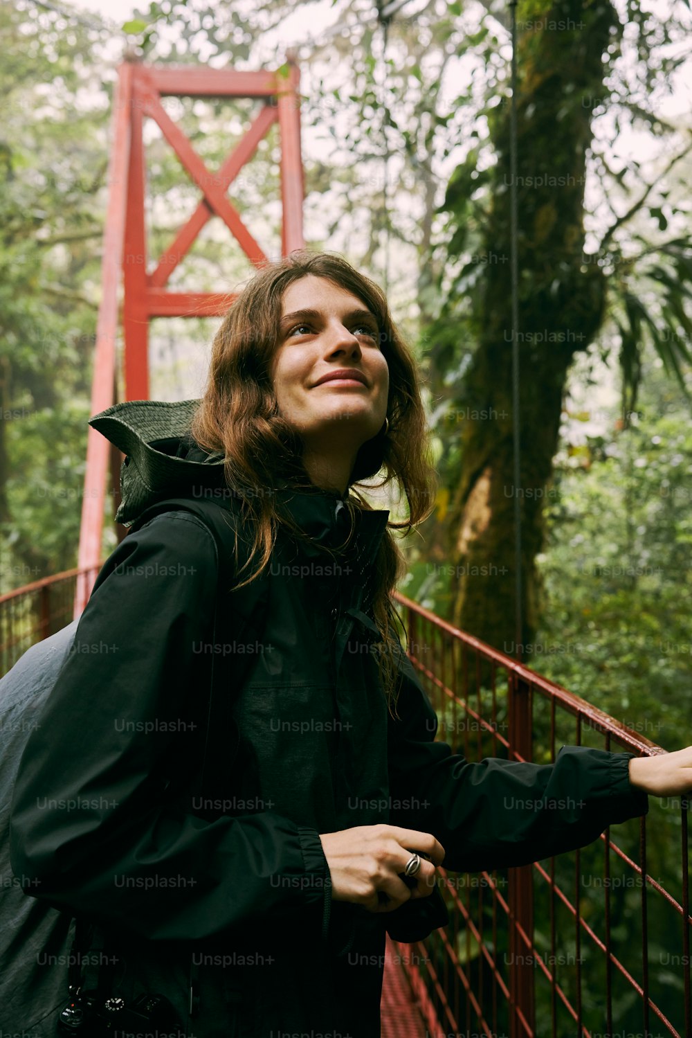 a woman standing on a bridge in the woods