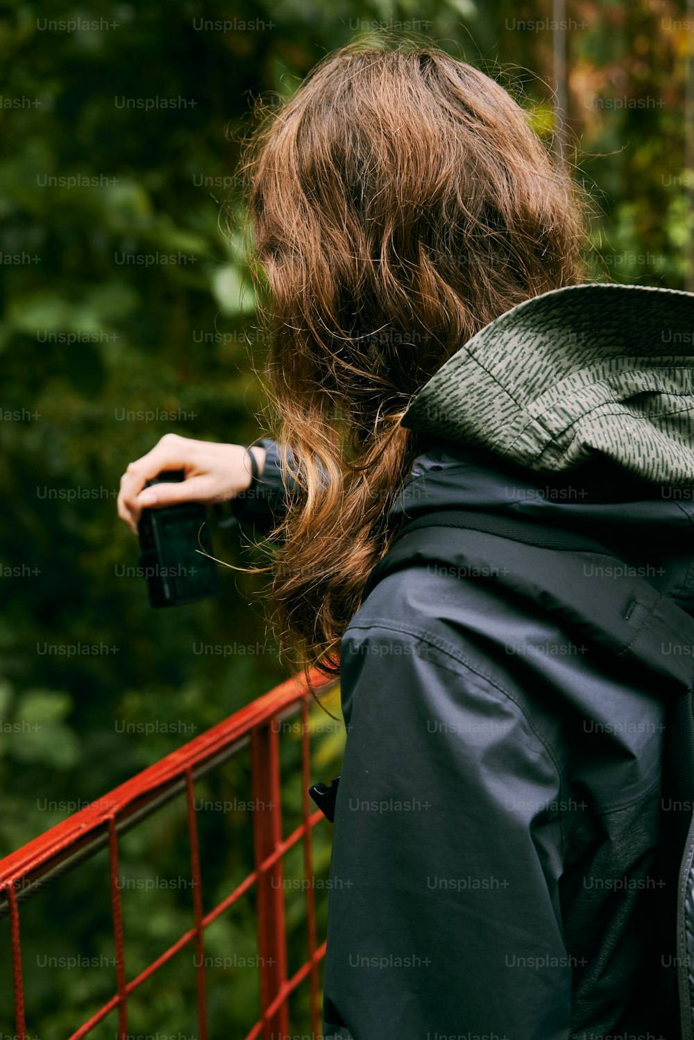 a woman standing on a bridge with her back to the camera