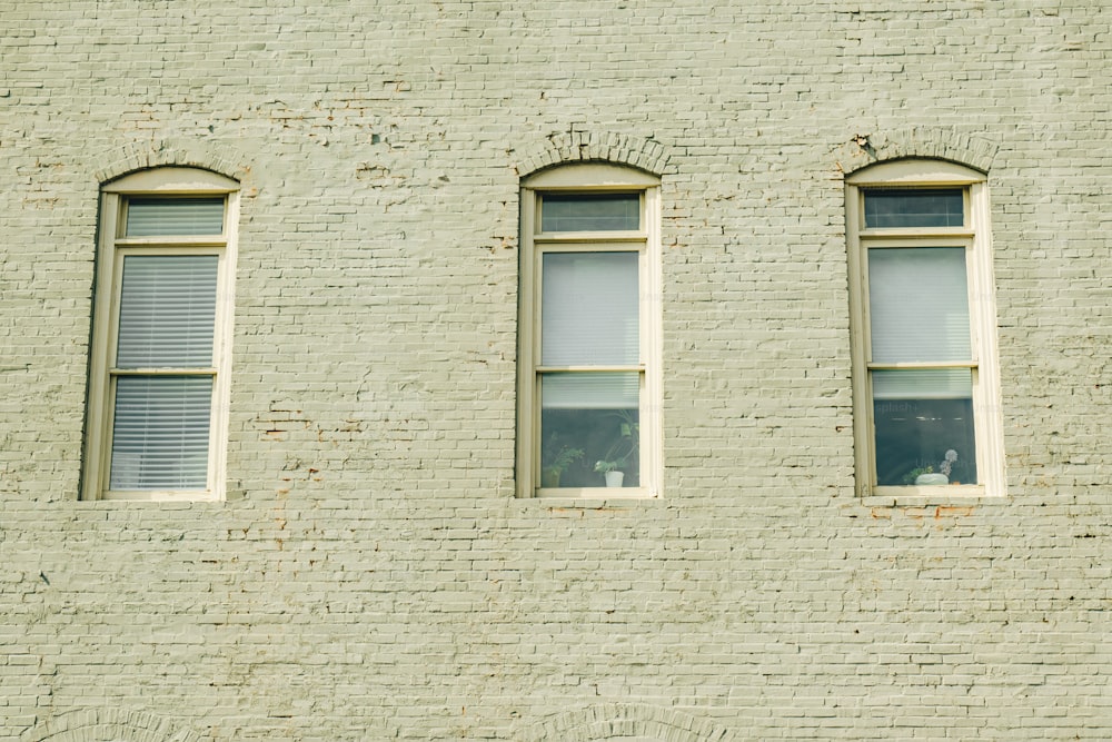 drei Fenster an der Seite eines Backsteingebäudes