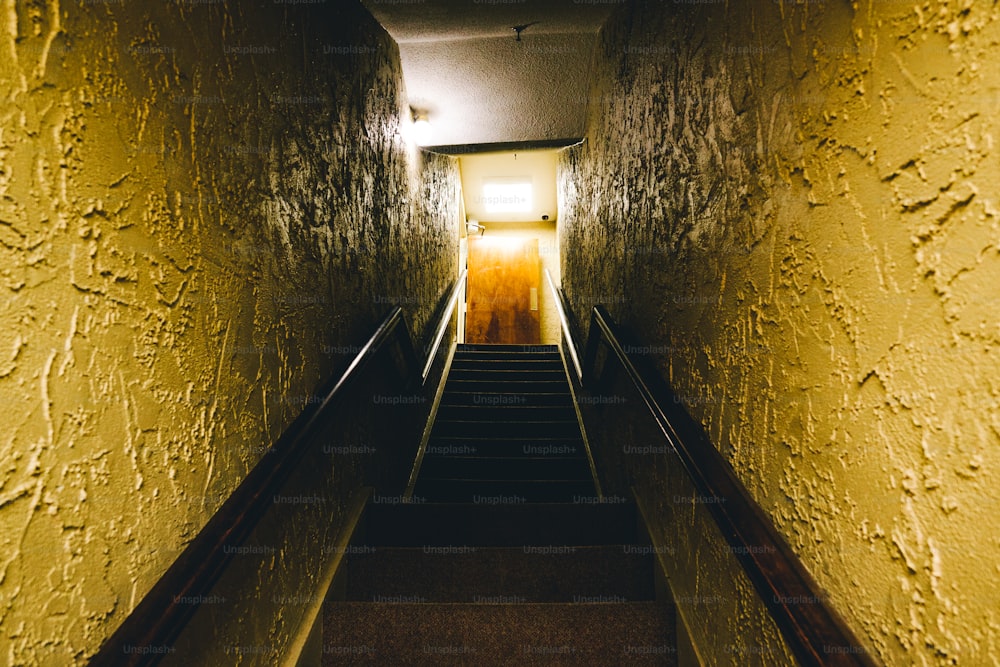 a set of stairs leading up to a light at the end of the tunnel