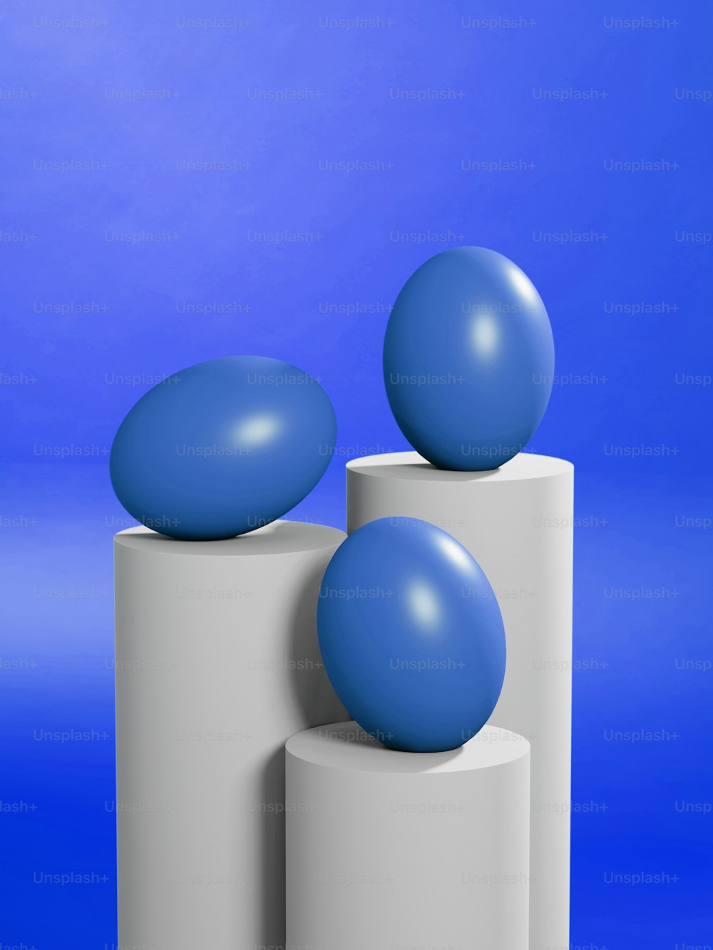 a blue ball sitting on top of two white cylinders