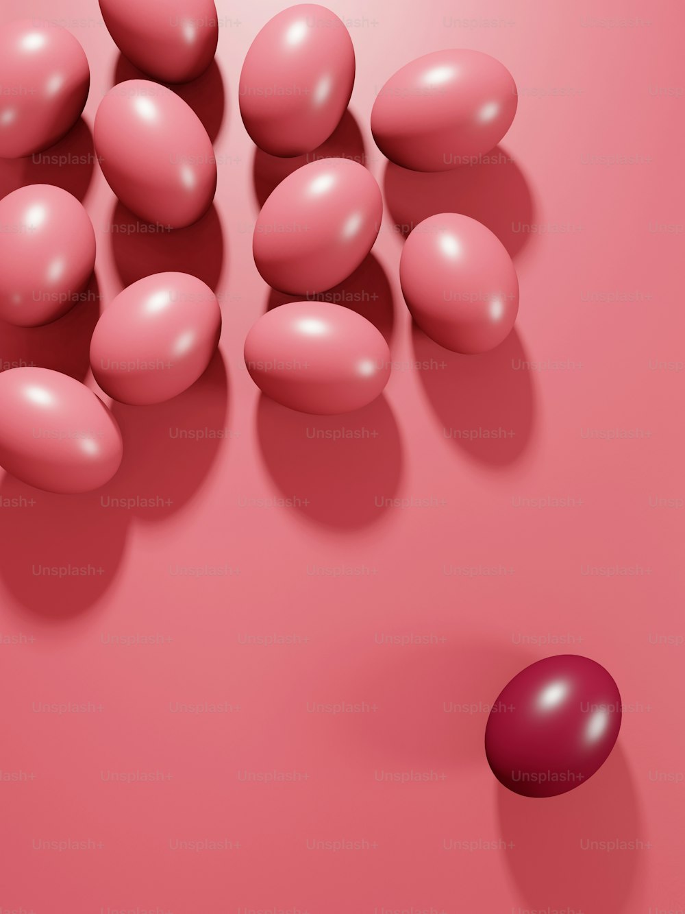 a group of pink balls and a red ball on a pink surface