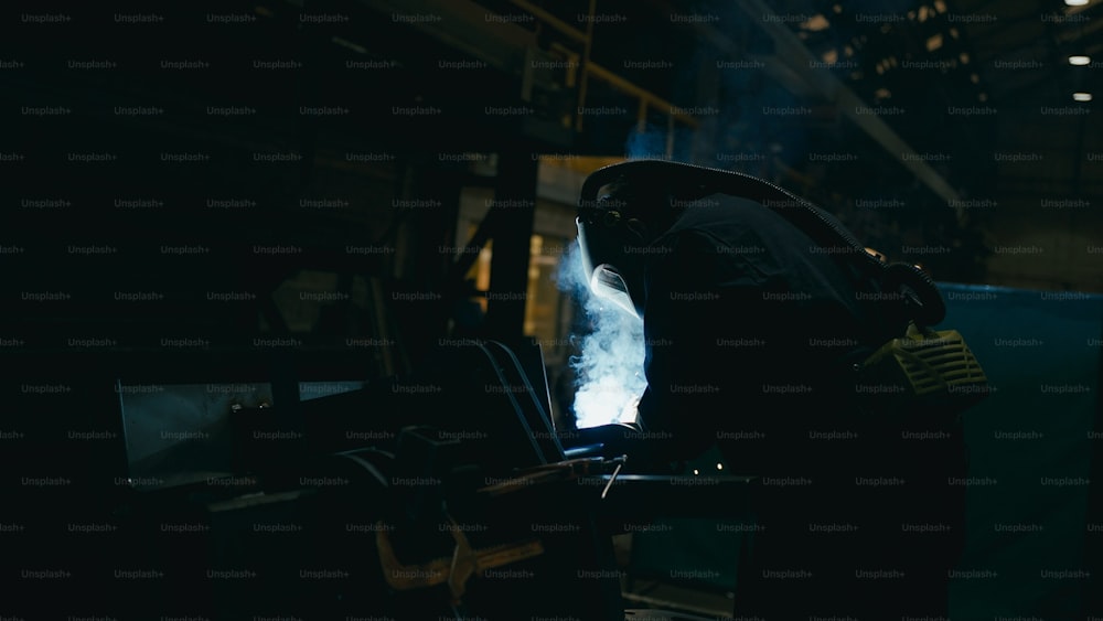 uma pessoa em pé em um quarto escuro com fumaça saindo de suas costas
