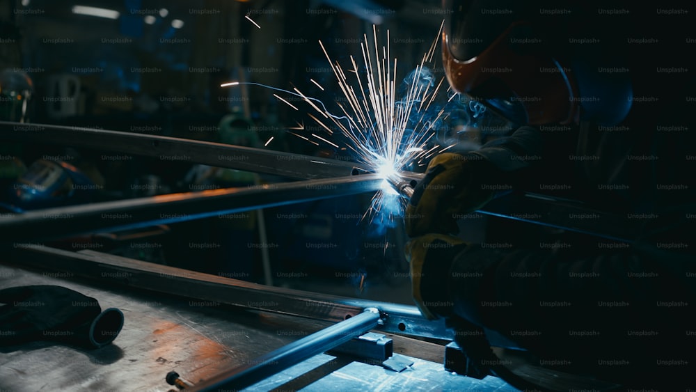 um soldador trabalhando em um pedaço de metal