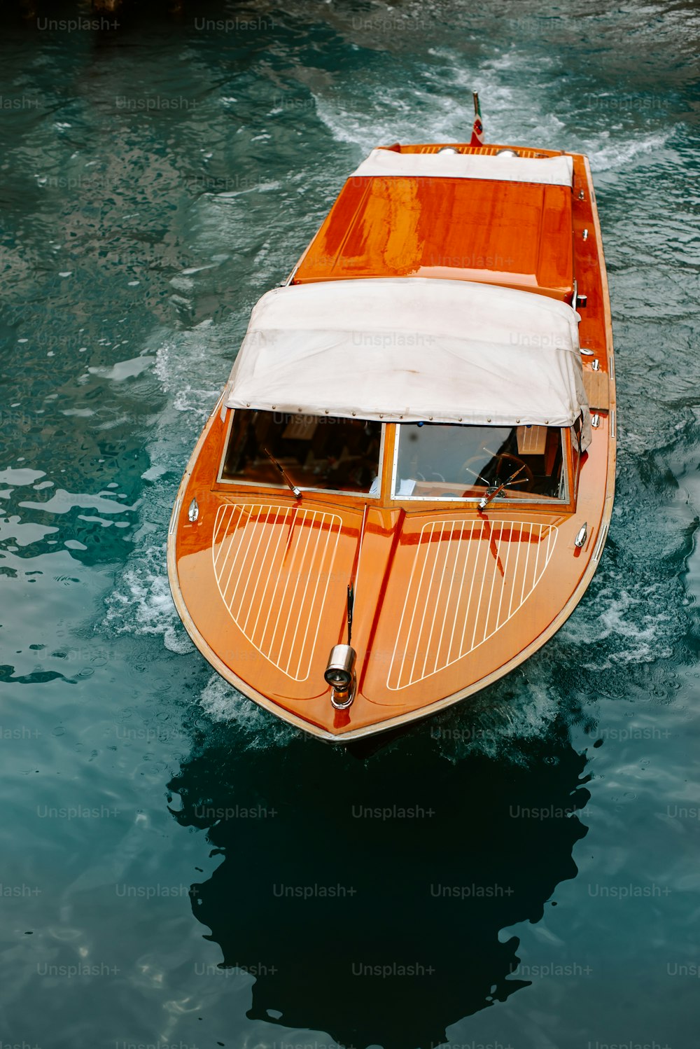 Una barca arancione e bianca in uno specchio d'acqua