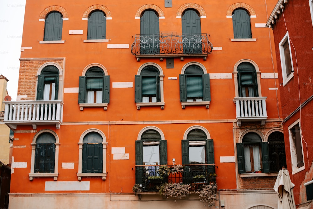 an orange building with green shutters and balconies
