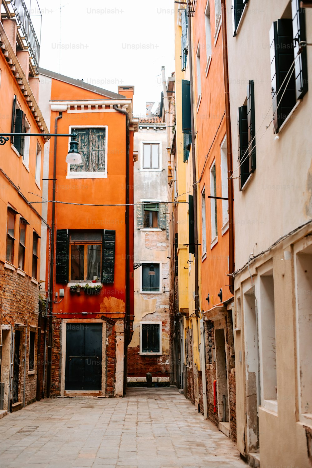 a narrow alleyway in a city with orange buildings