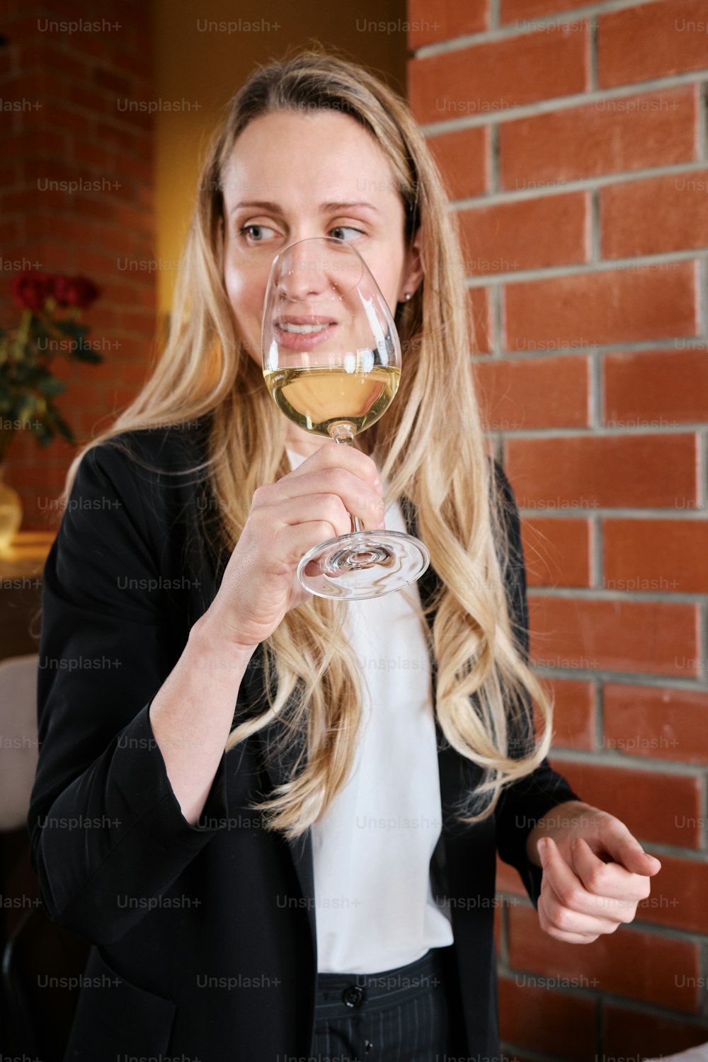 Una mujer sosteniendo una copa de vino blanco