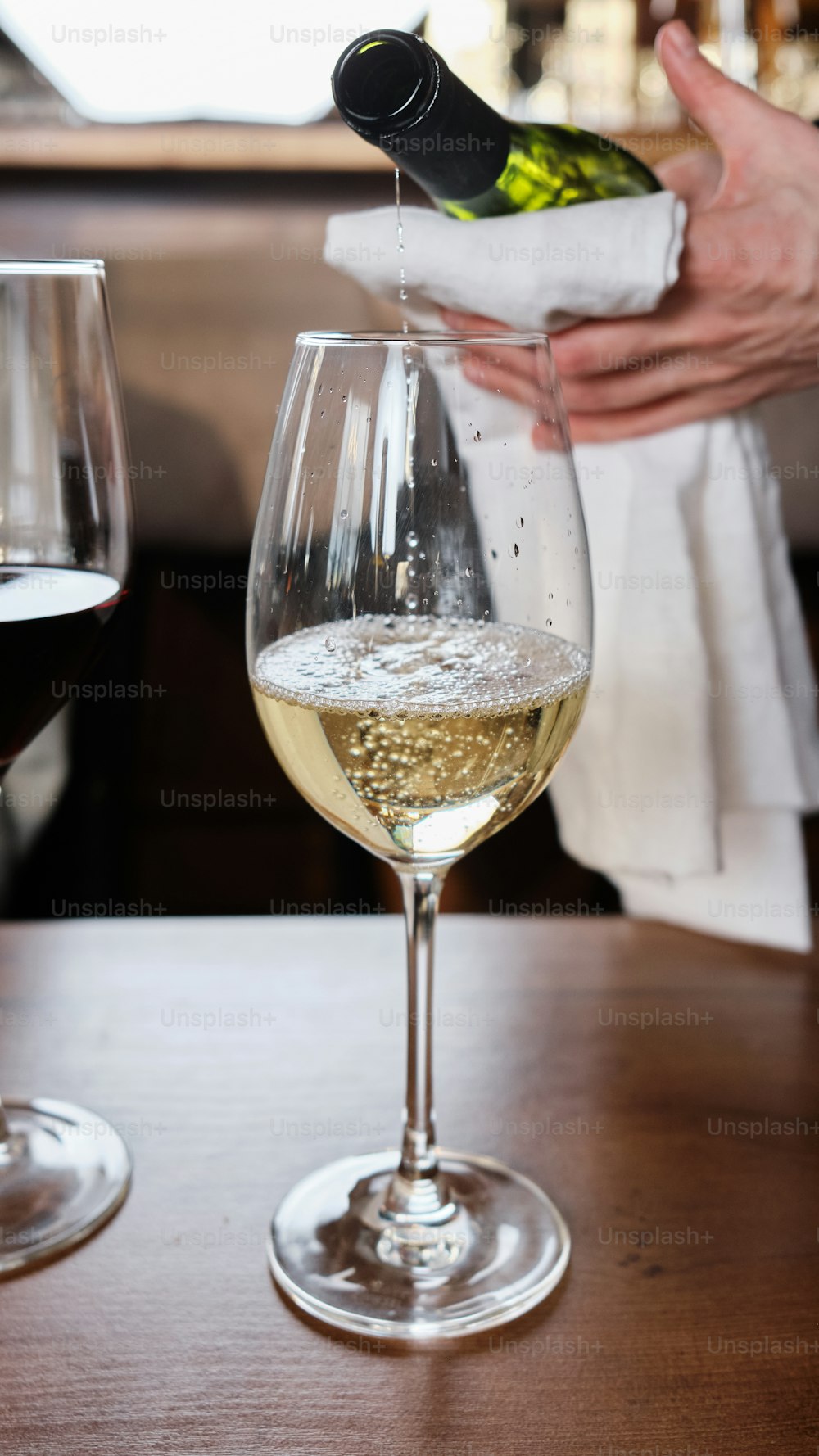 a person pouring a glass of wine into a wine glass