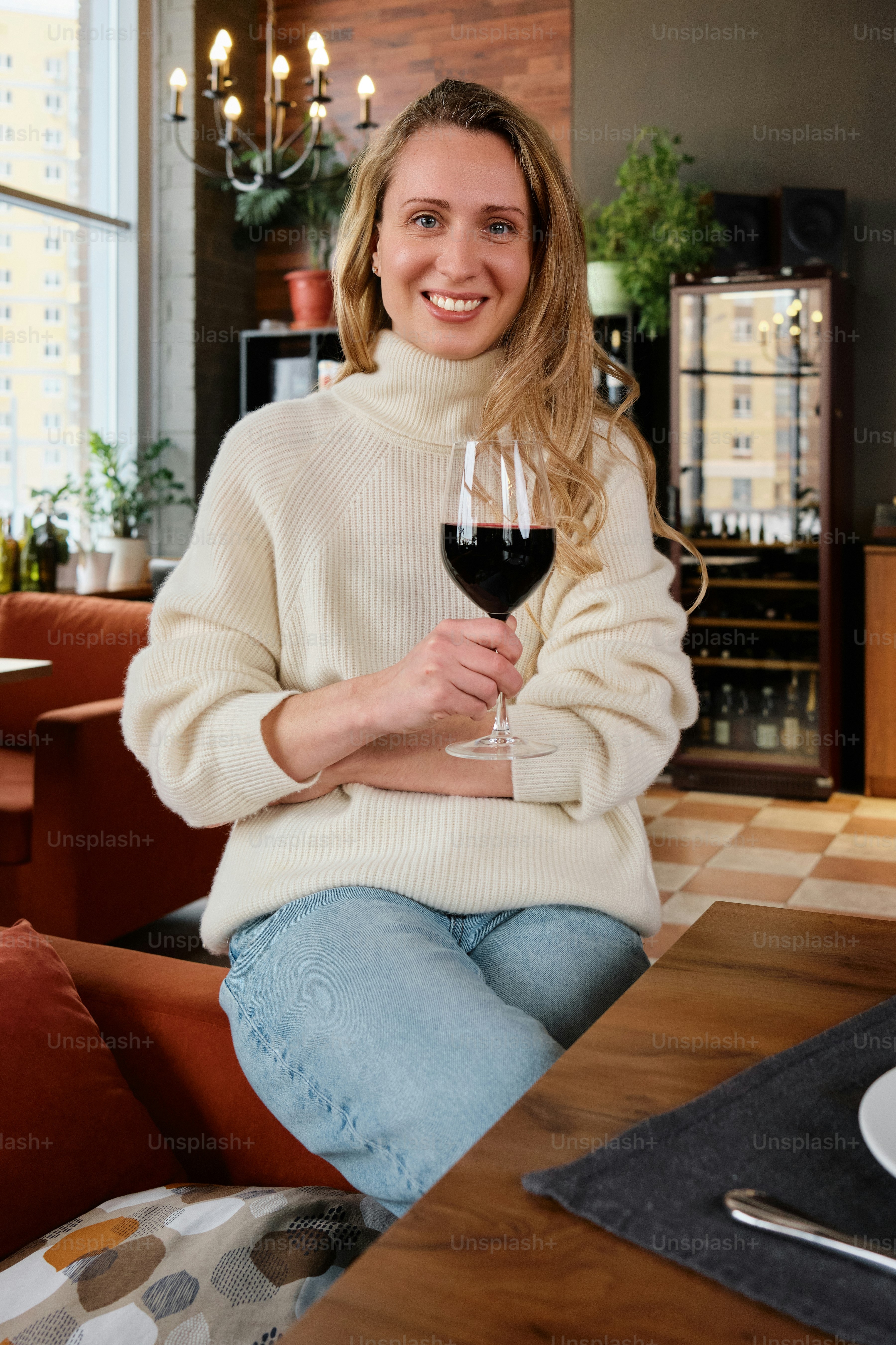 a woman sitting at a table with a glass of wine