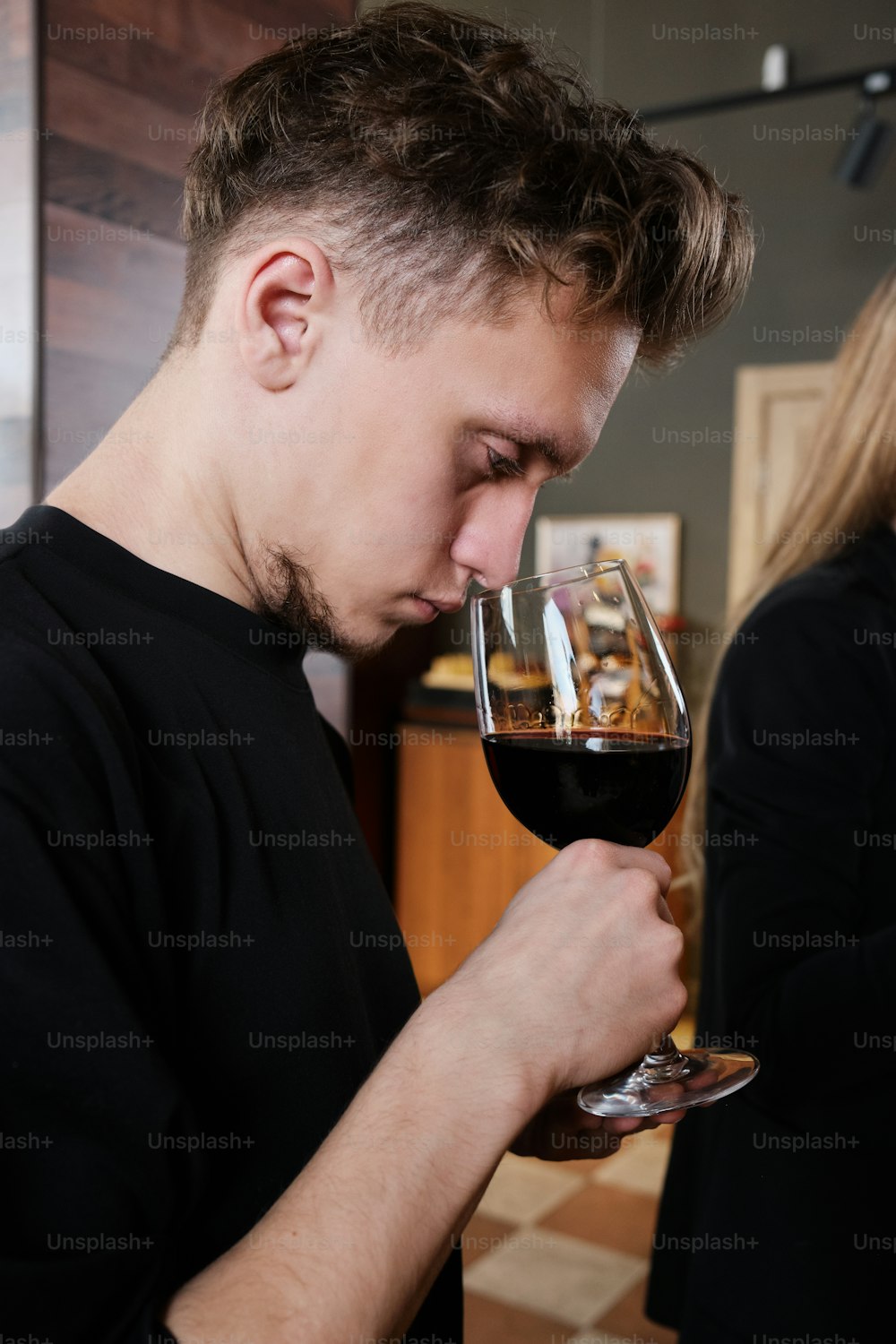 a man drinking a glass of red wine