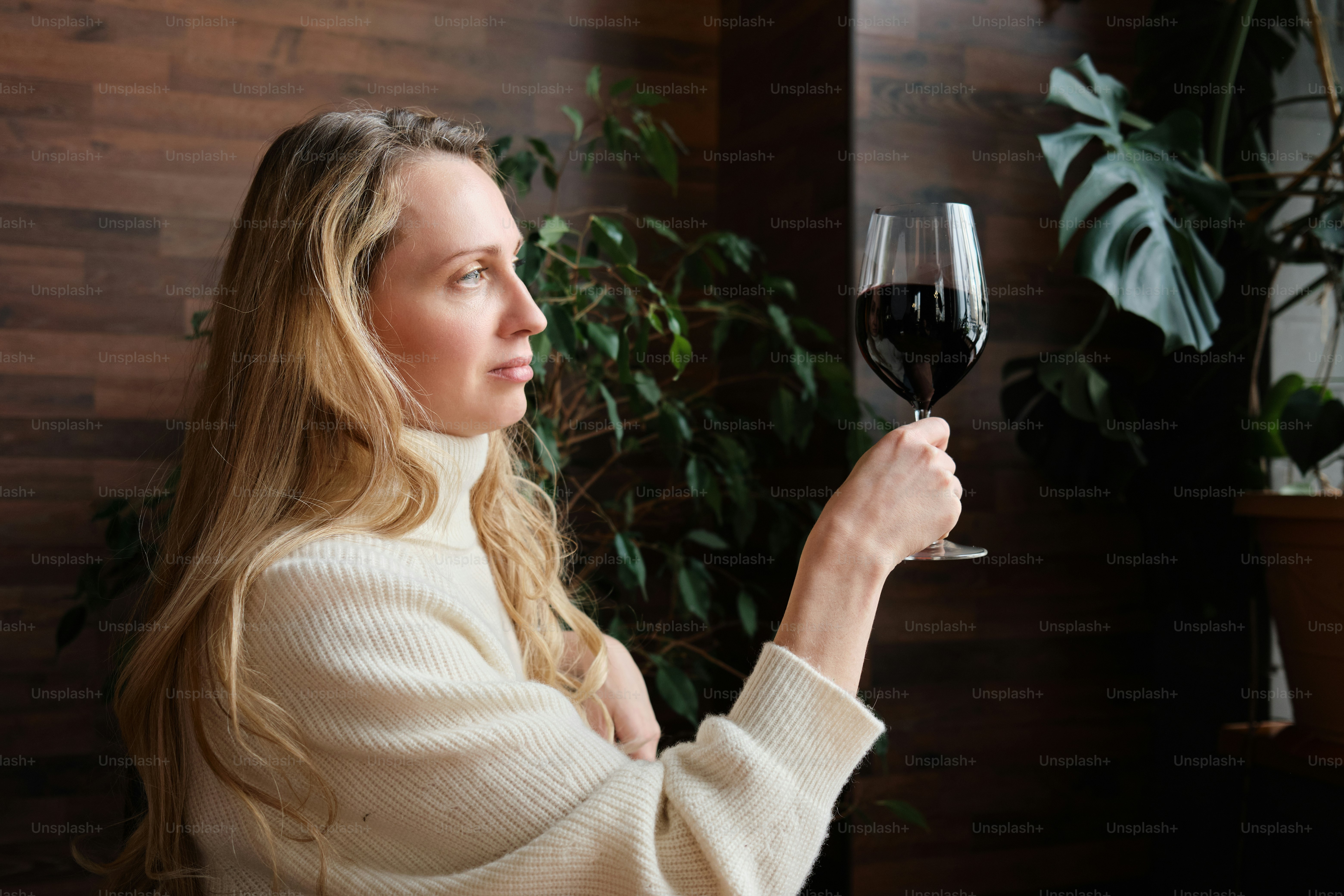 A woman holding a glass of red wine photo  Luxury Image on Unsplash