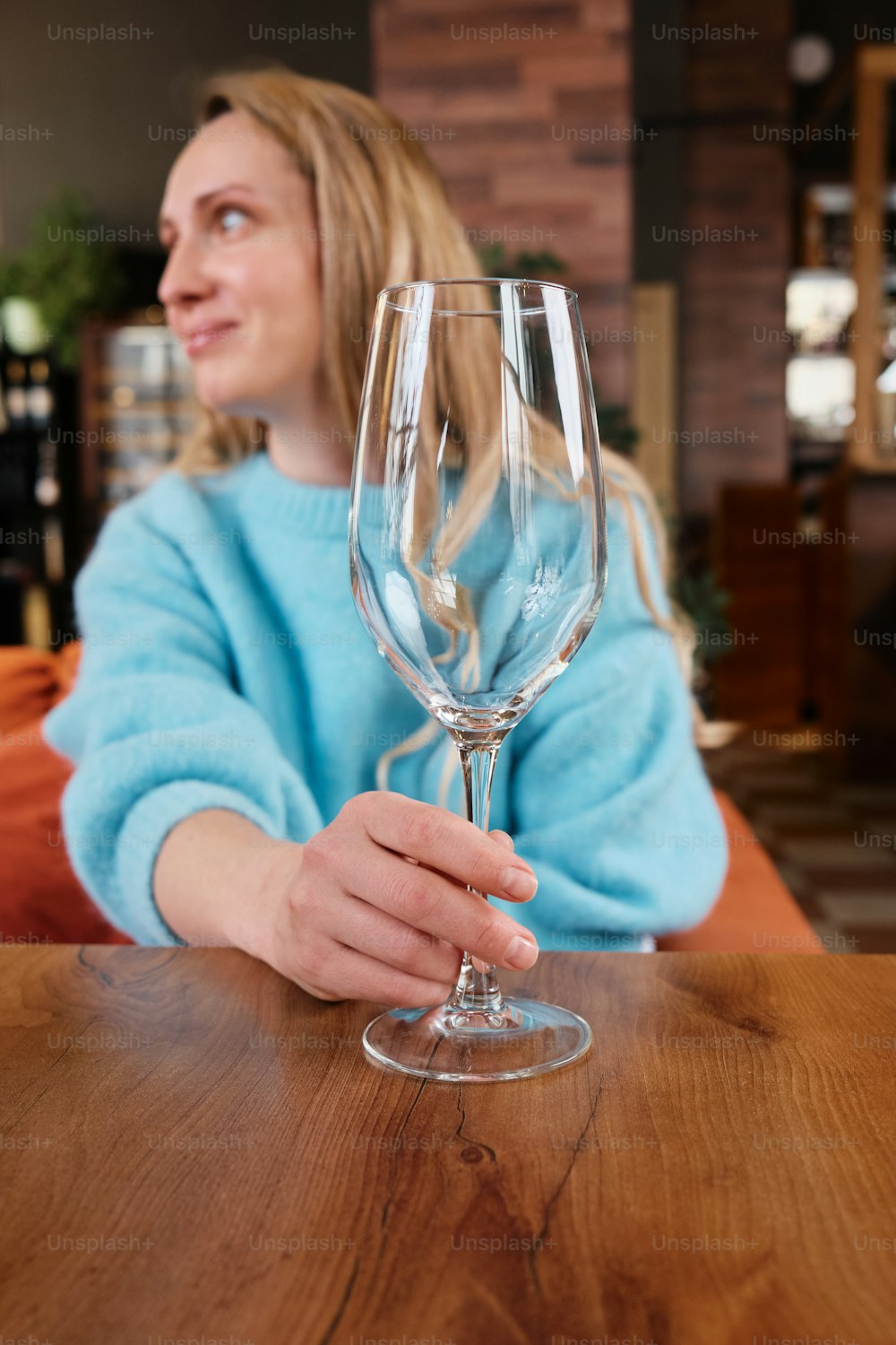 Eine Frau sitzt an einem Tisch mit einem Weinglas