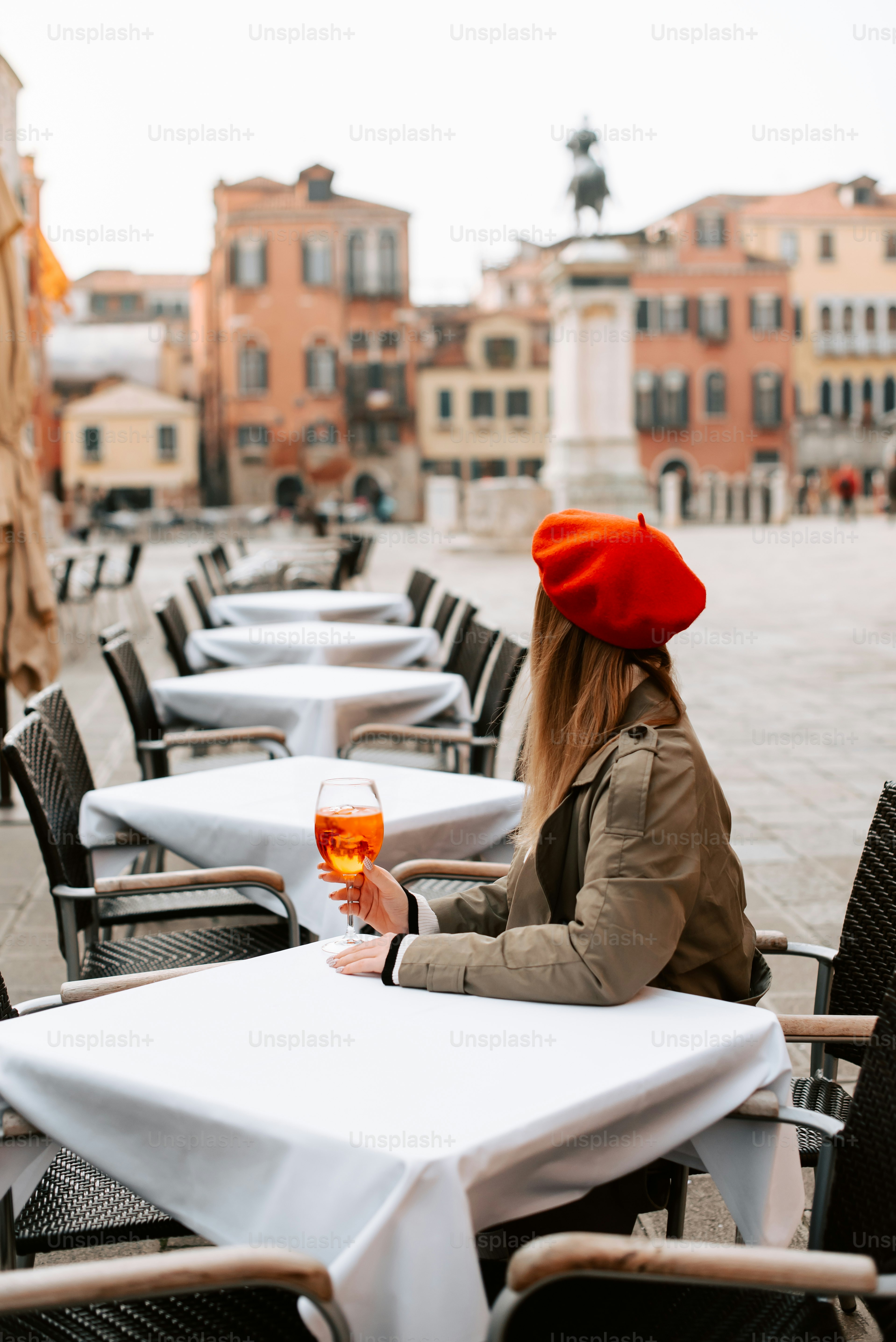 a woman sitting at a table with a glass of wine