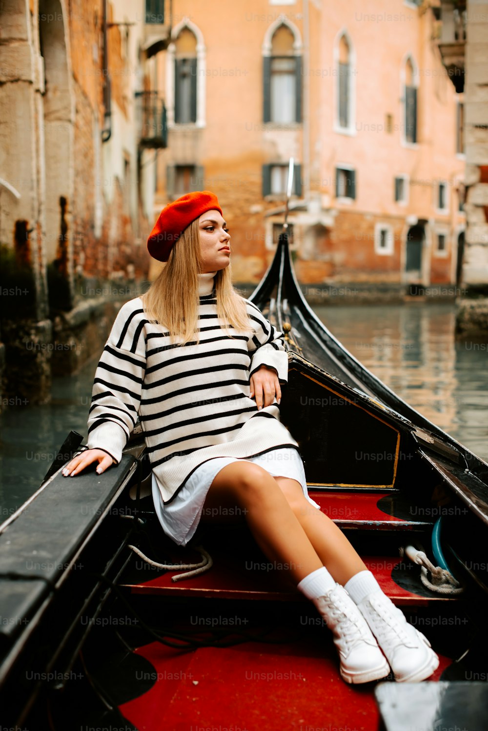 a woman sitting on a boat in a canal