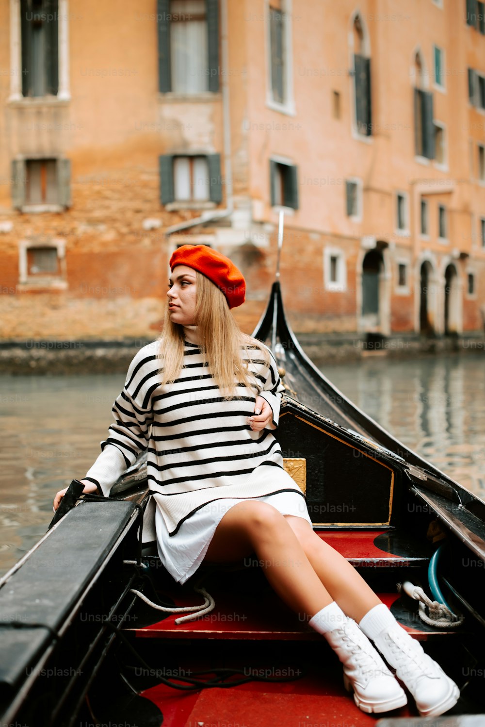 a woman sitting on a boat in a canal