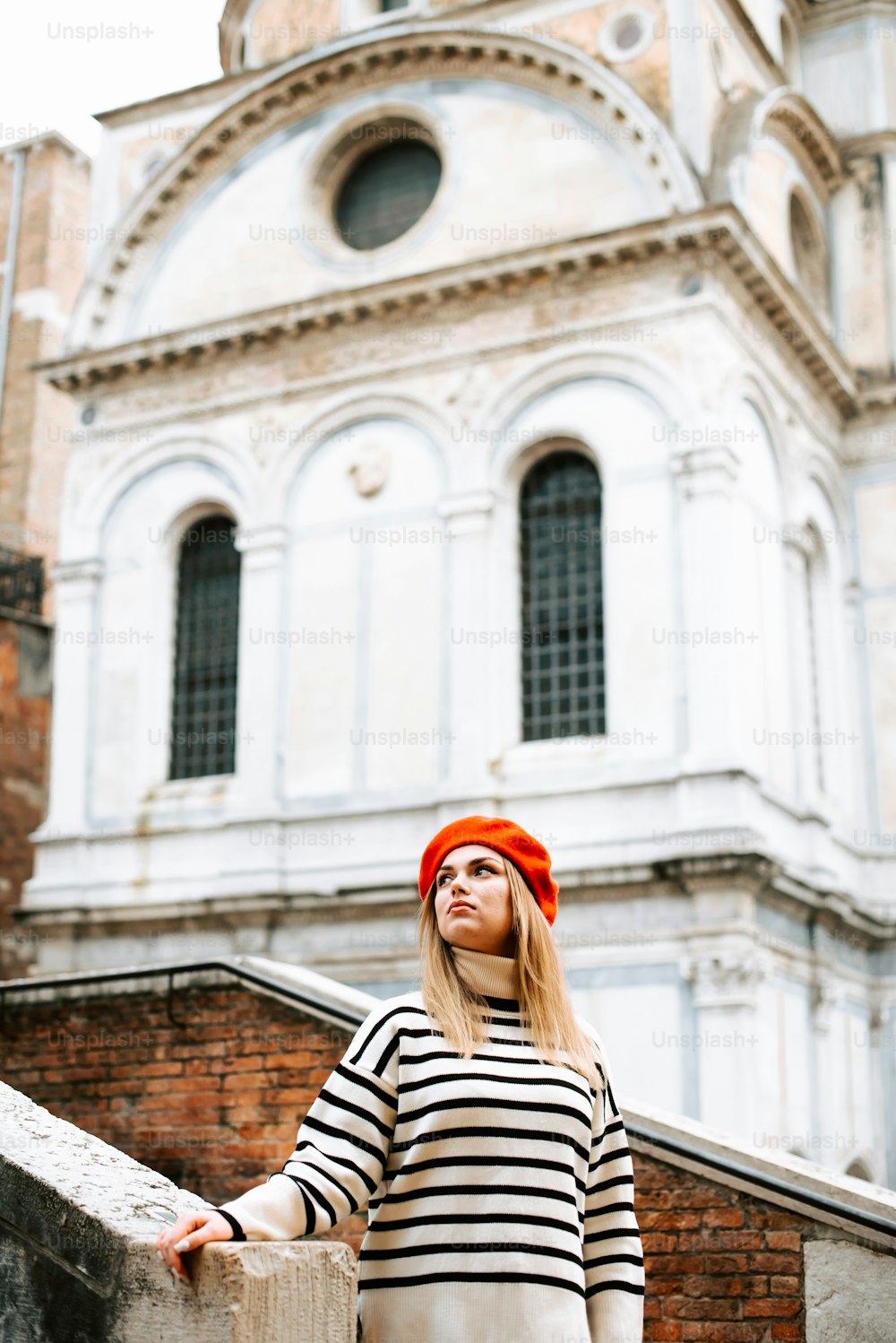 a woman in a striped shirt and orange hat