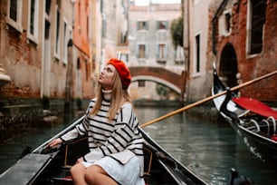 a woman sitting in a boat on a canal