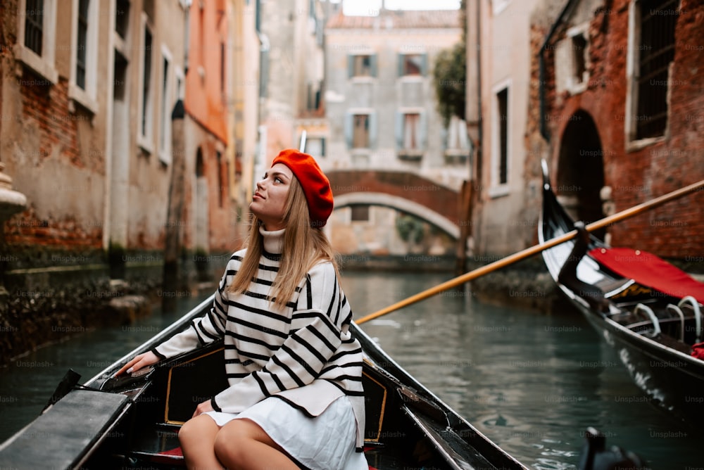 a woman sitting in a boat on a canal