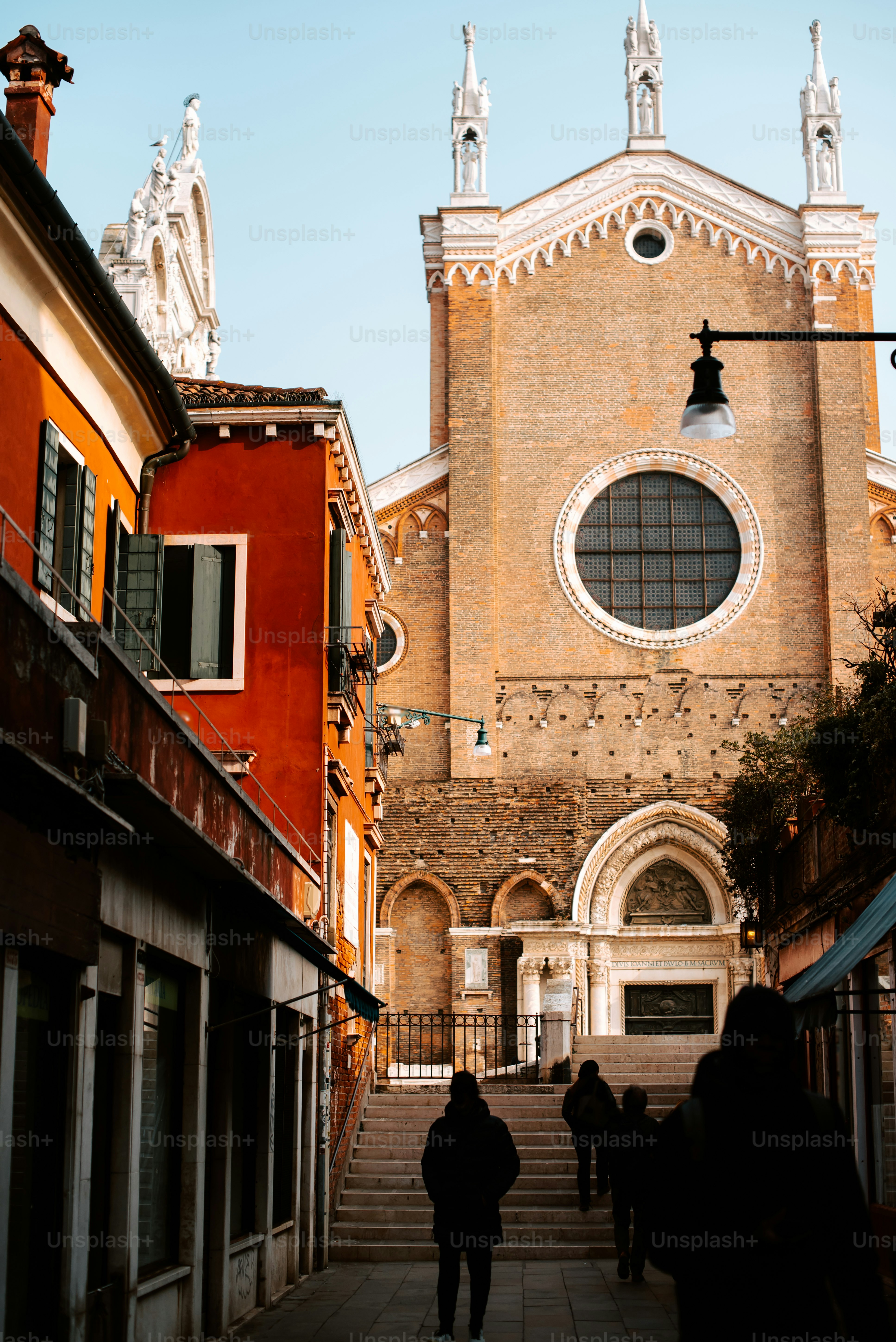 two people walking down a street in front of a church