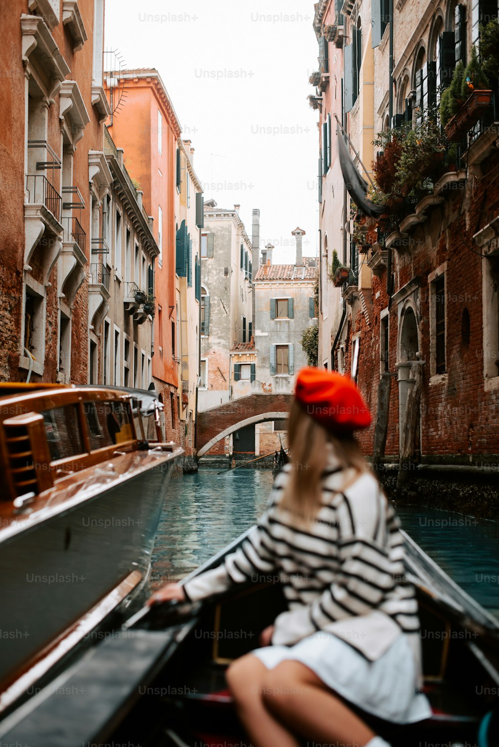 a woman sitting in a boat on a canal