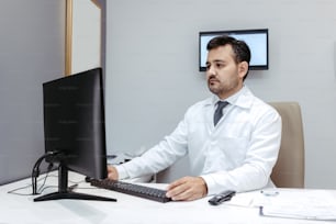 コンピューターのモニターの前に座っている男性