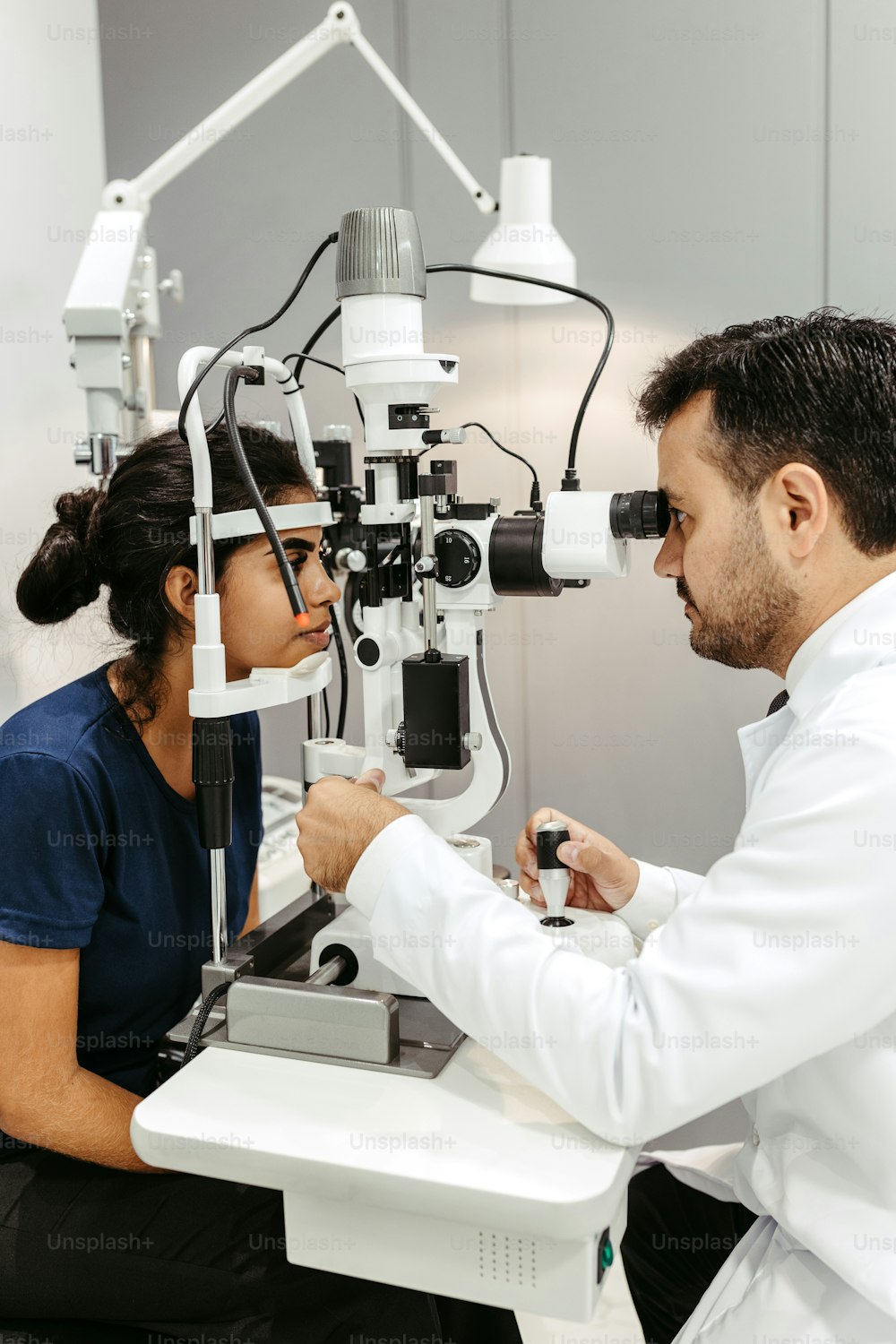 a man looking through a microscope at a woman
