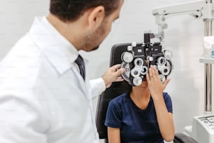 a woman getting her eye examined by a doctor
