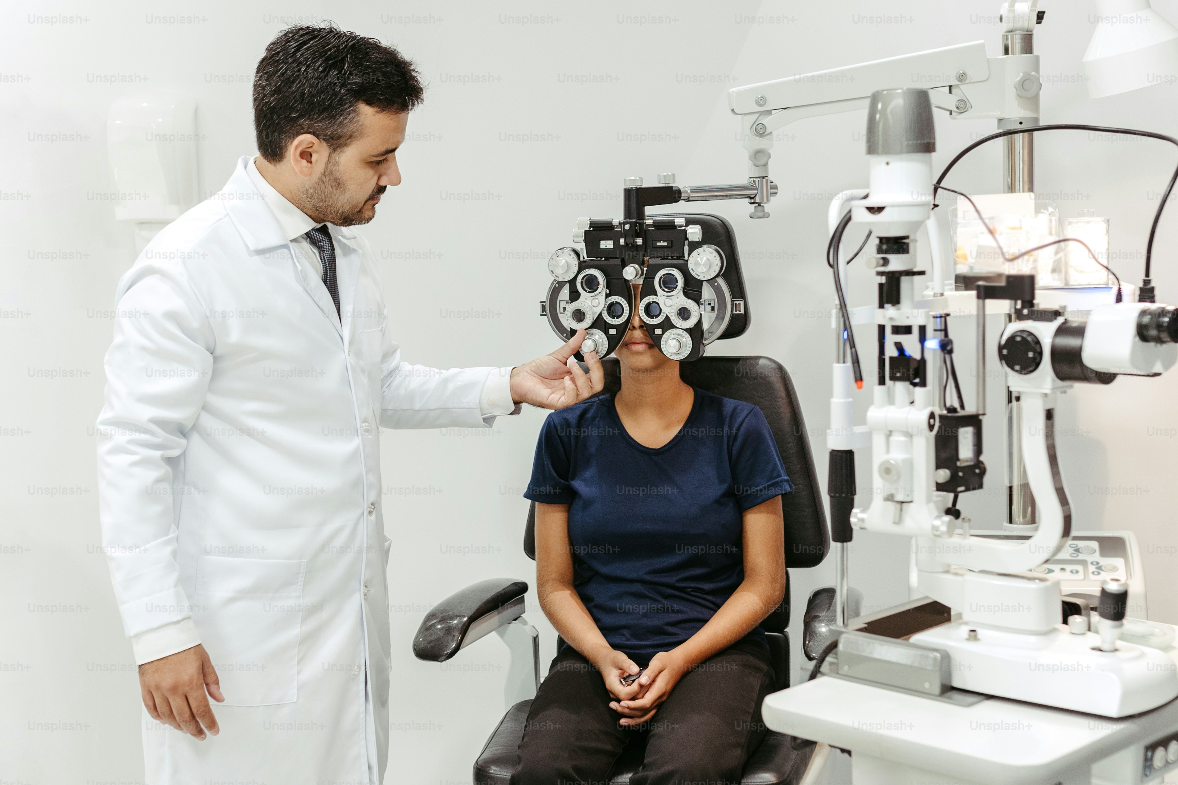 a woman sitting in a chair next to a man in a white lab coat