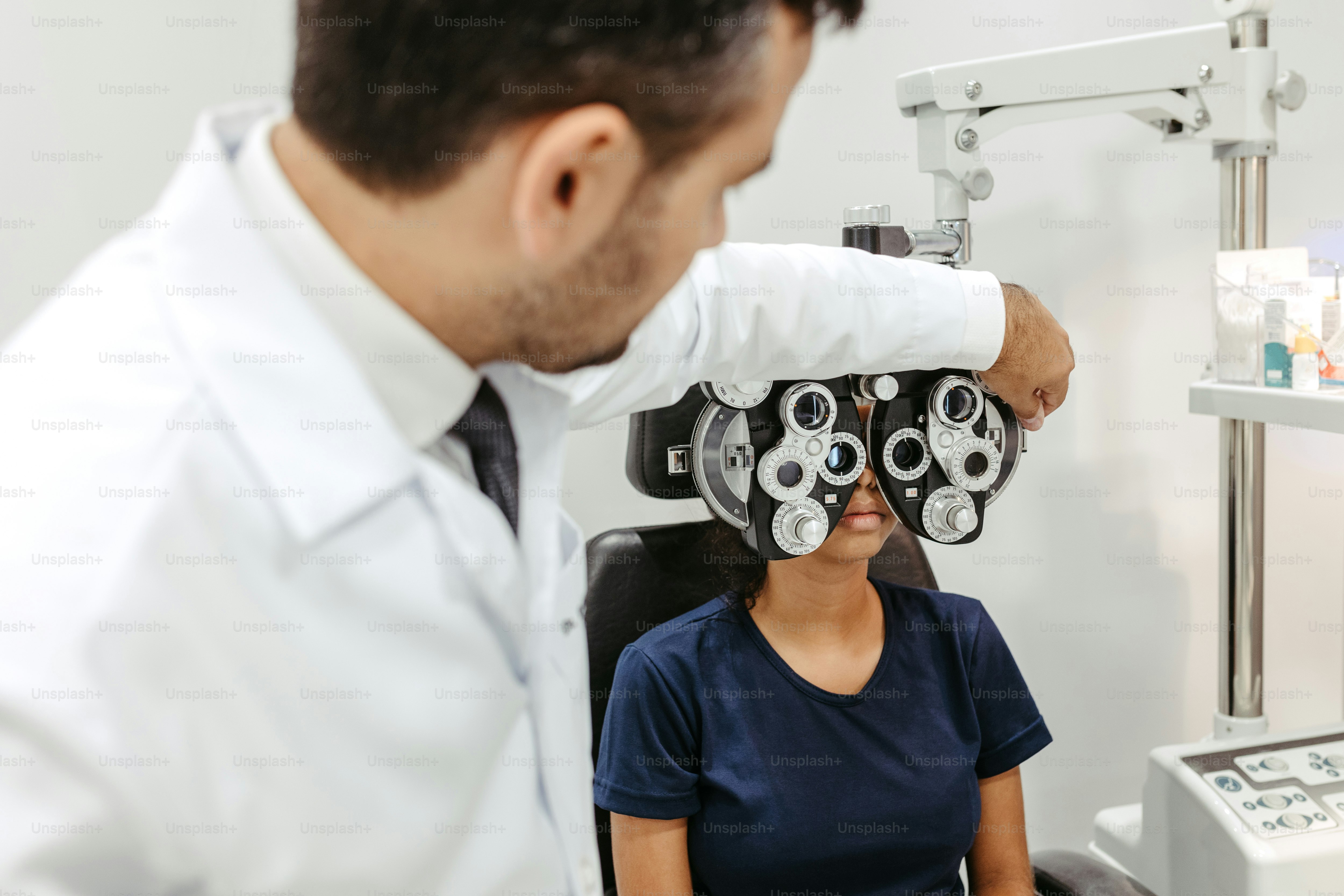 a woman sitting in a chair looking at a man in a white lab coat