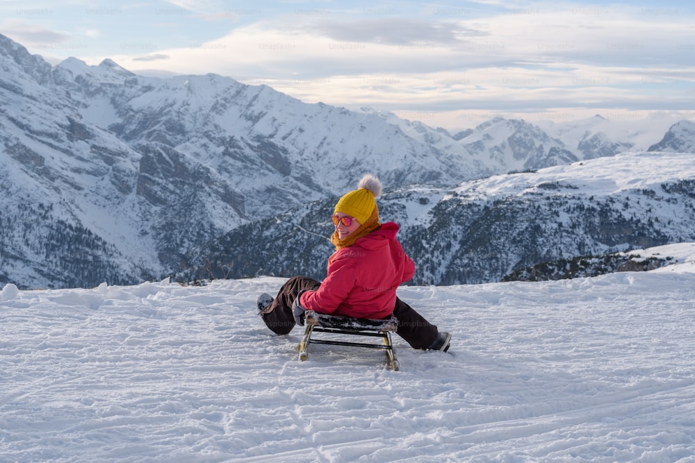 una persona seduta su una panchina nella neve