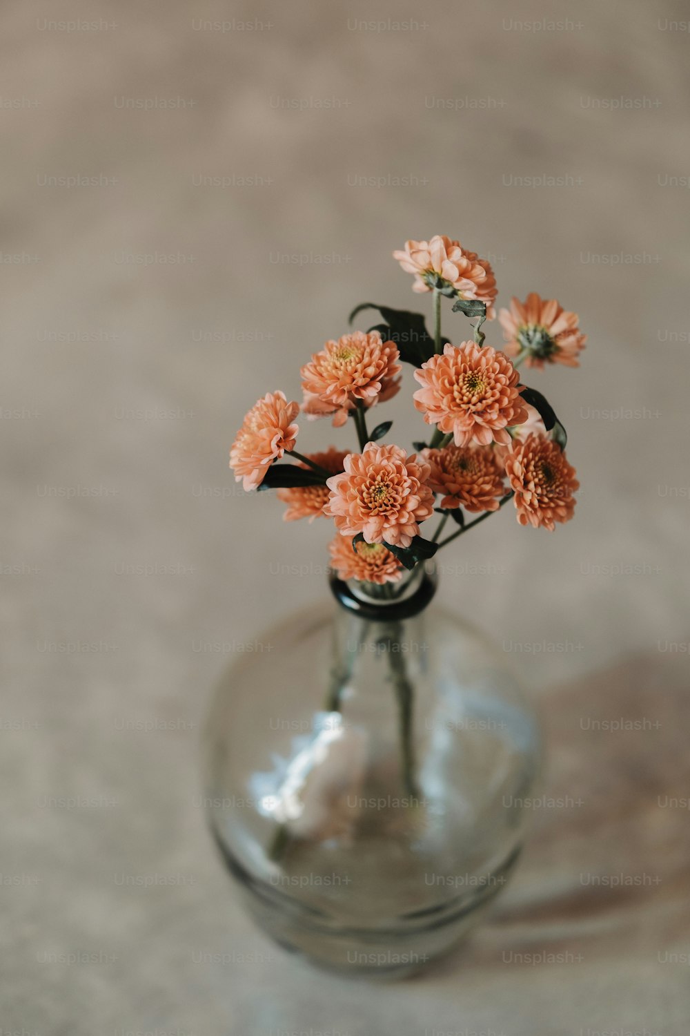 um vaso de vidro cheio de flores em cima de uma mesa