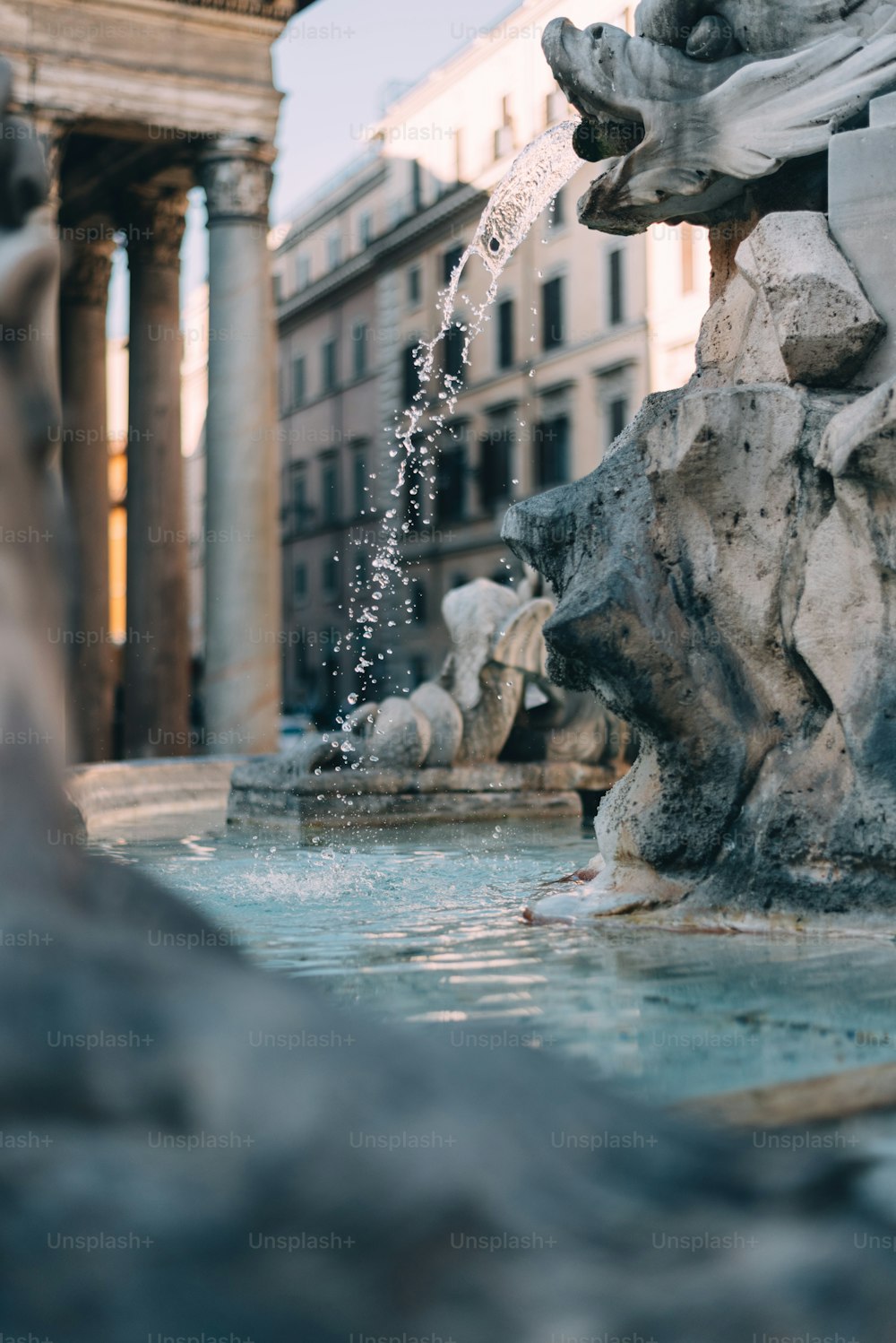 a water fountain with a clock tower in the background