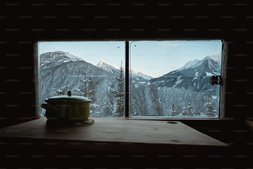 a tea pot sitting on top of a table next to a window