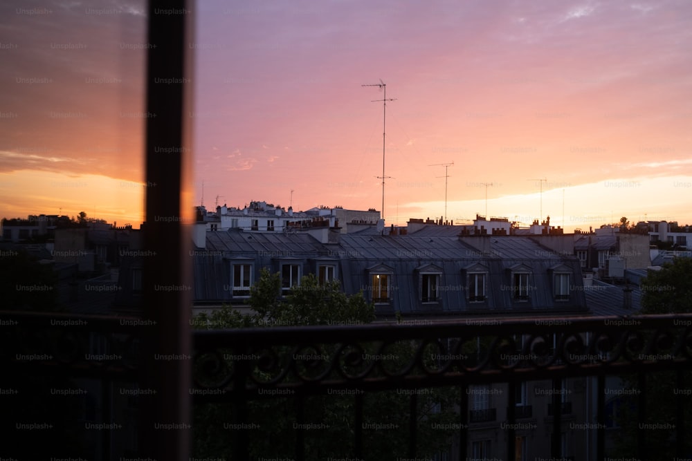 Blick auf eine Stadt bei Sonnenuntergang von einem Balkon
