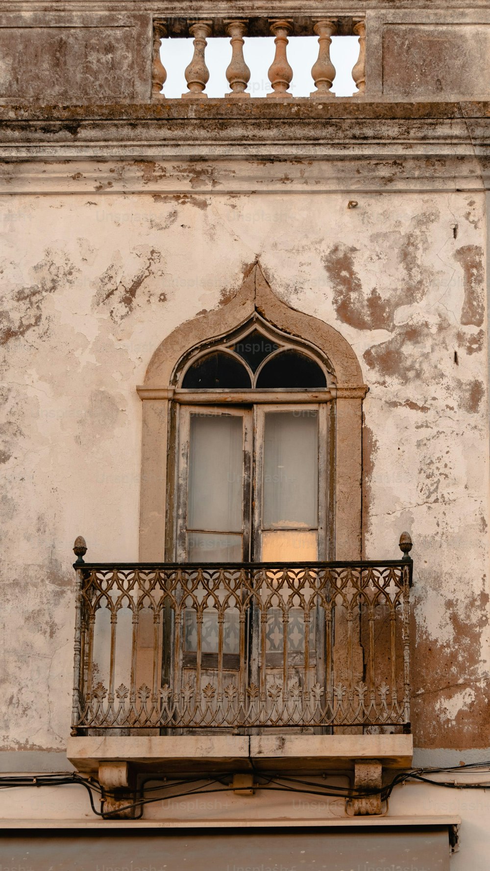 um edifício antigo com uma varanda e uma janela