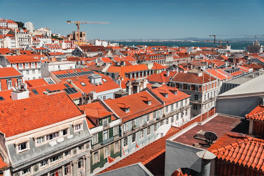 uma vista de uma cidade com telhados vermelhos e um guindaste no fundo