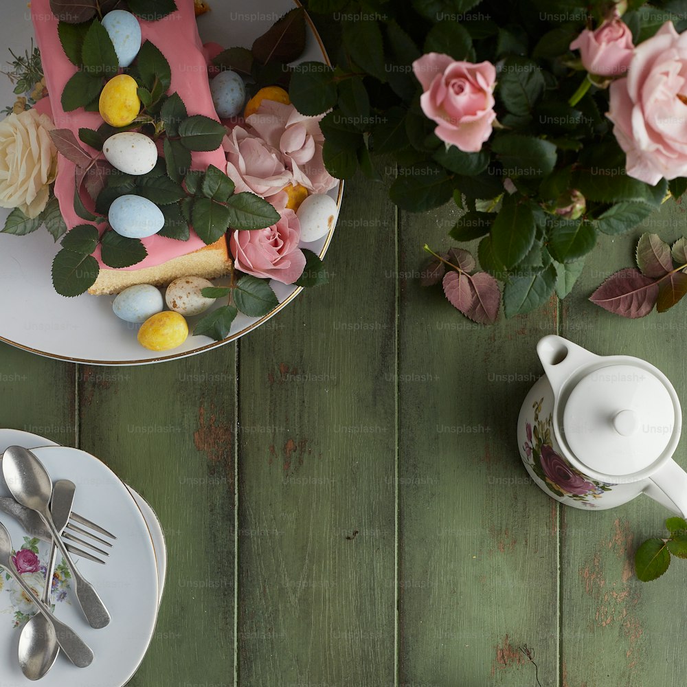 une table surmontée d’assiettes et de tasses remplies de fleurs