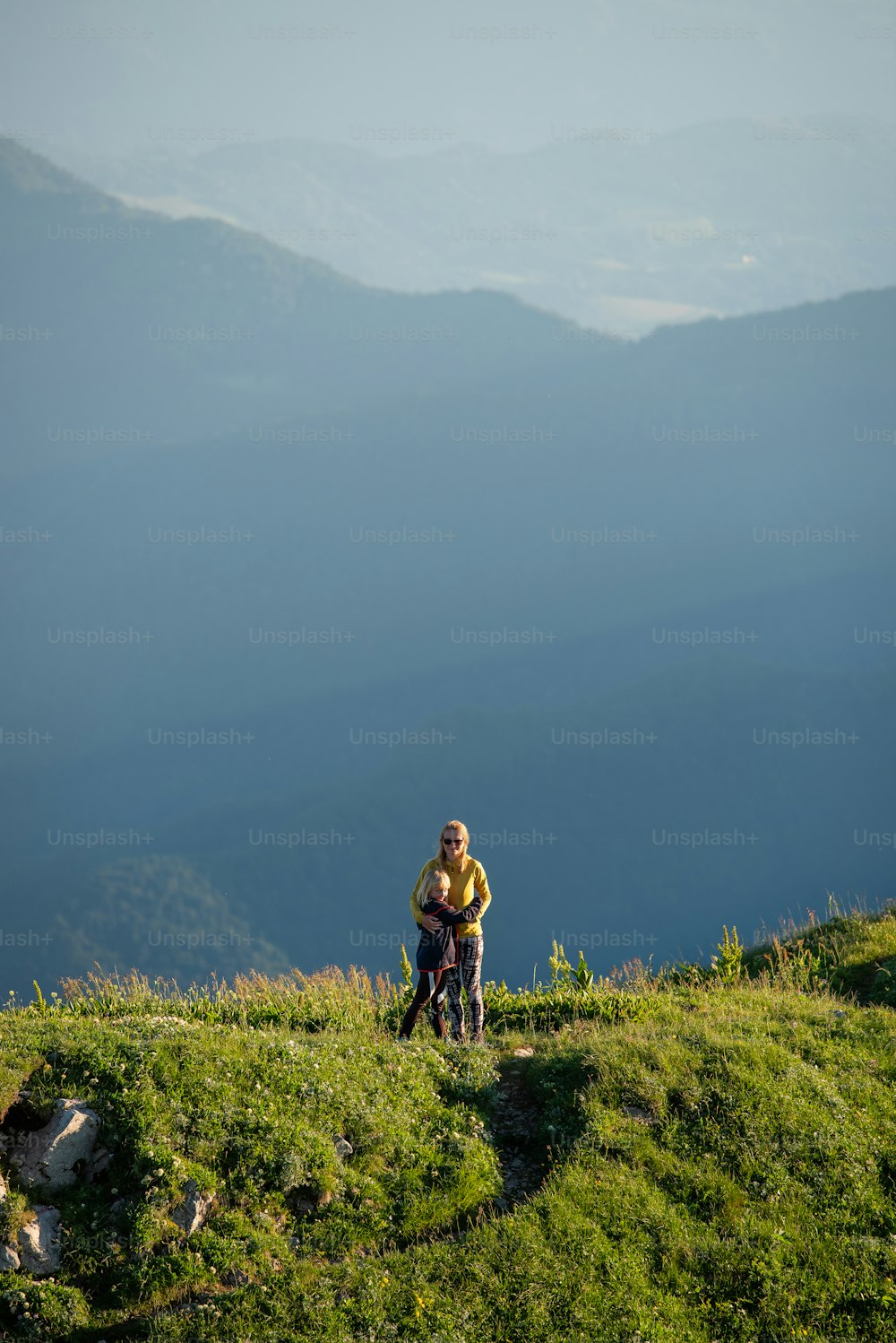 Un homme debout au sommet d’une colline verdoyante