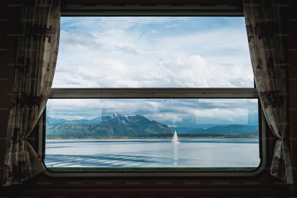 a window with a view of a lake and mountains