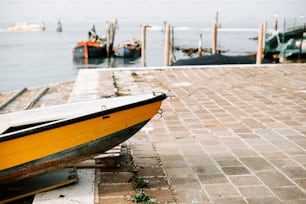 Ein gelbes Boot sitzt auf einem Pier