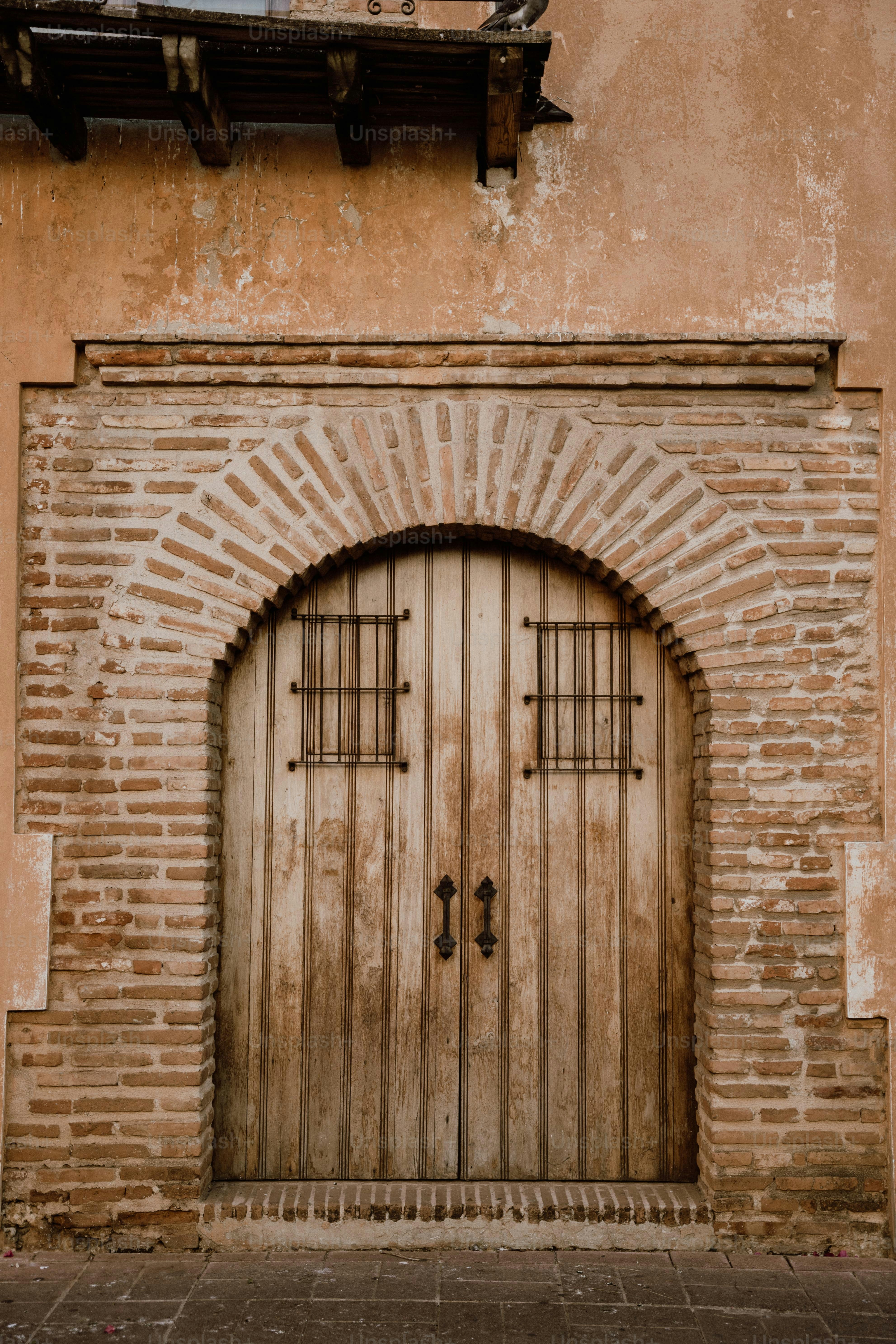 a brick building with a wooden door and arched window