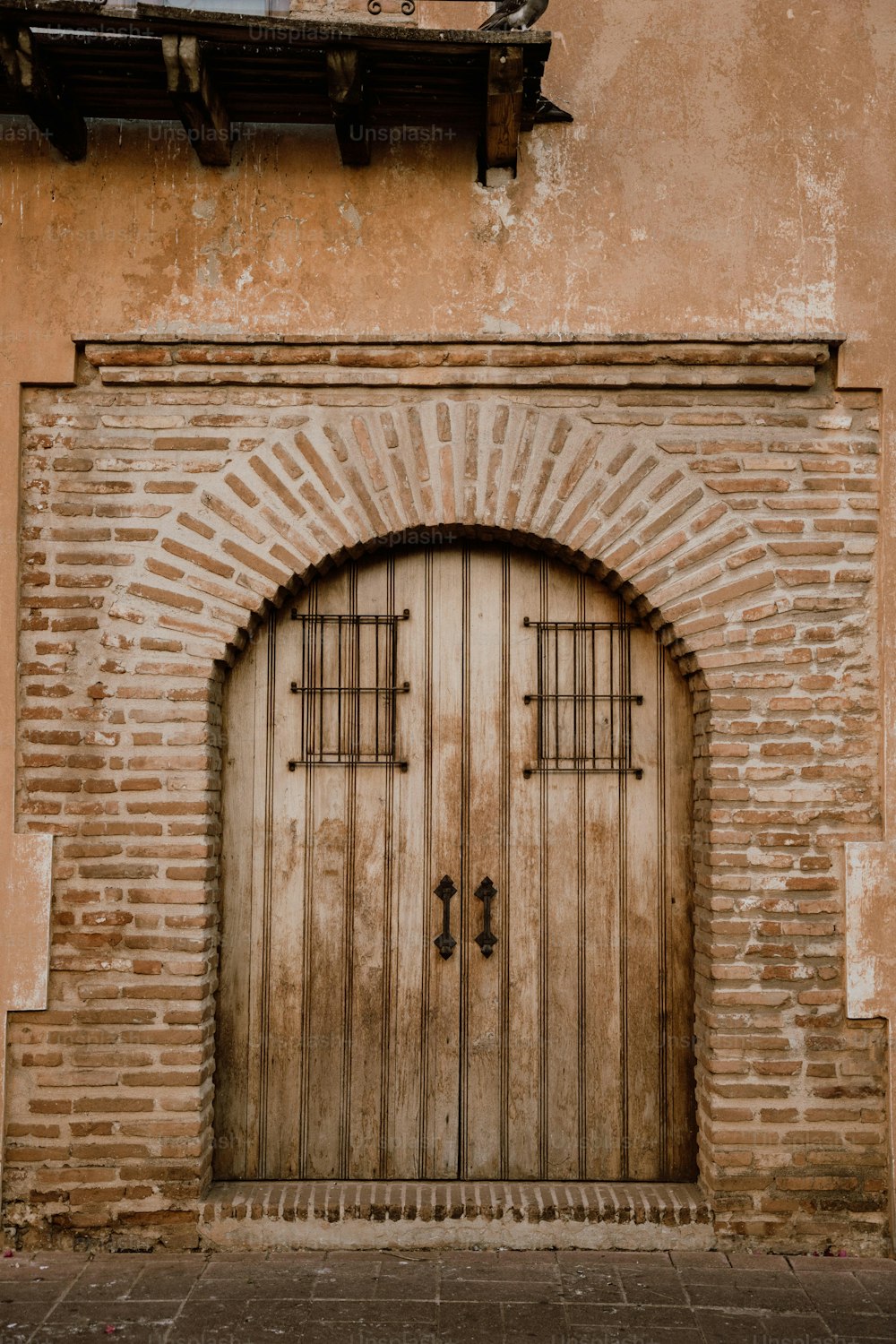 Un edificio de ladrillo con una puerta de madera y ventana arqueada