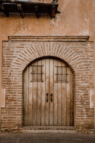 a brick building with a wooden door and arched window