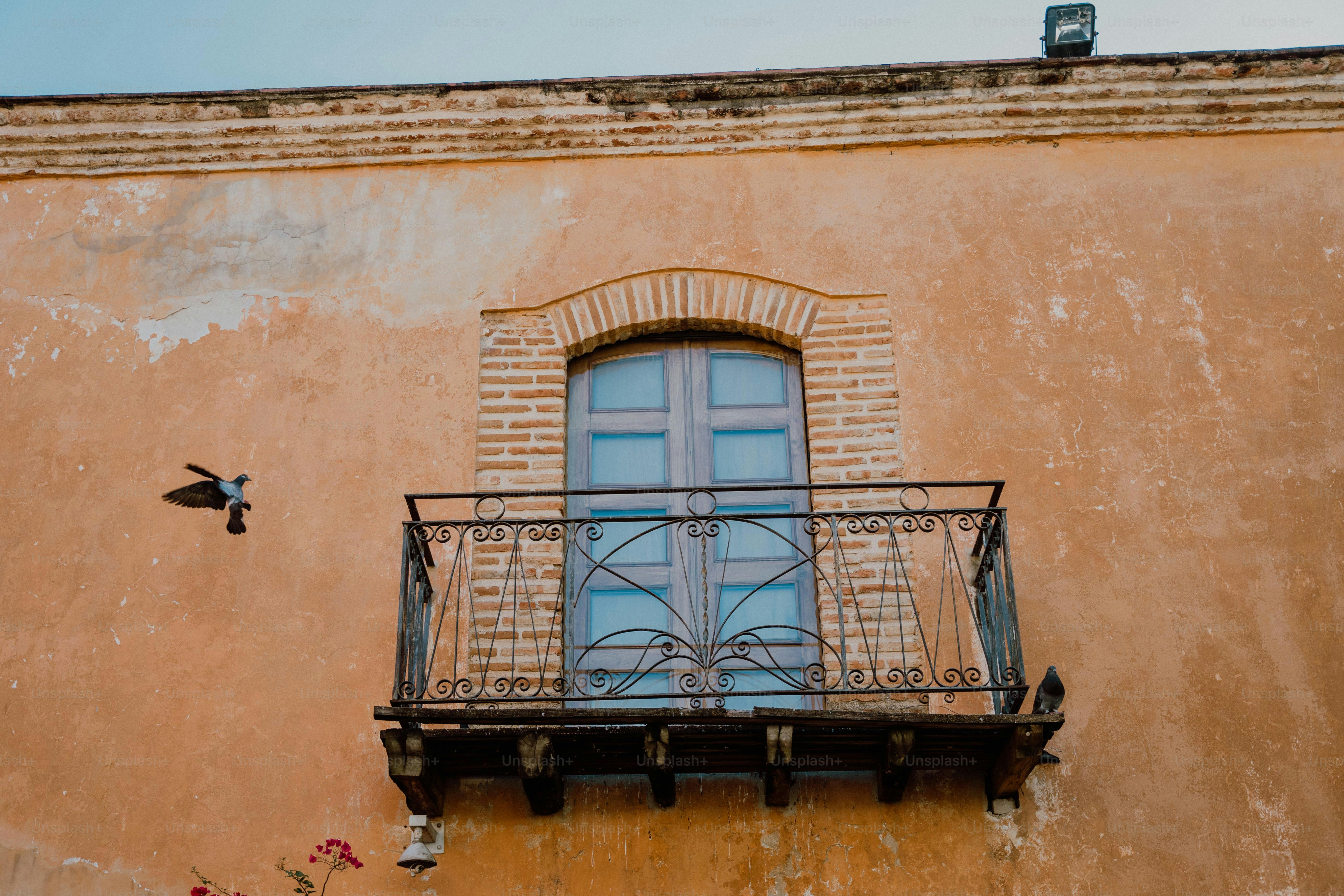 ein Balkon mit einem schmiedeeisernen Geländer und einem Fenster