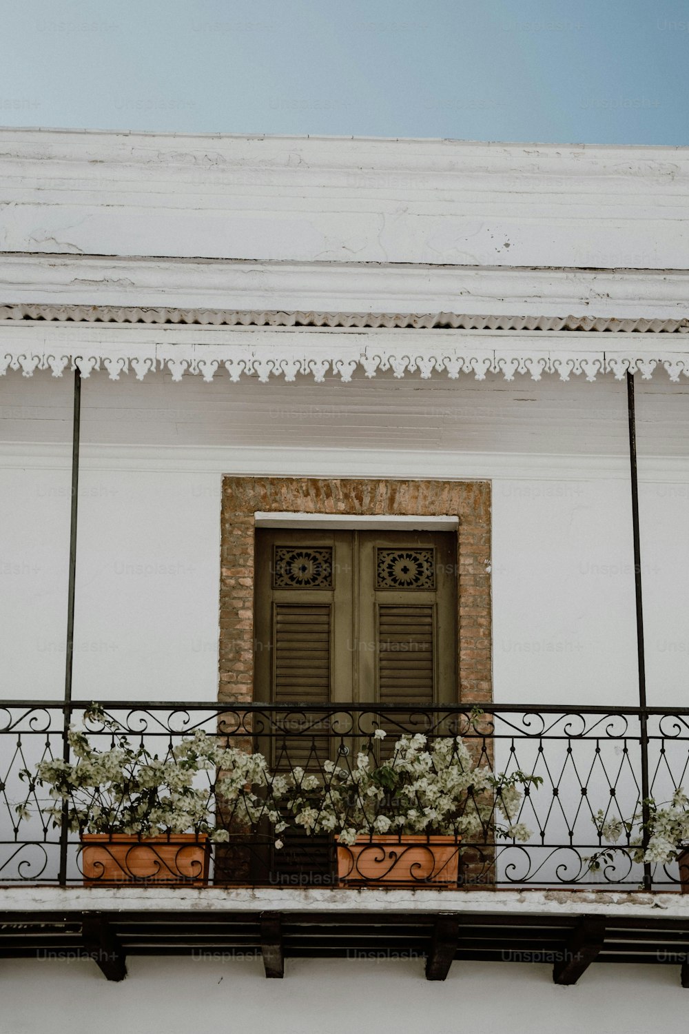 a balcony with potted plants and a door